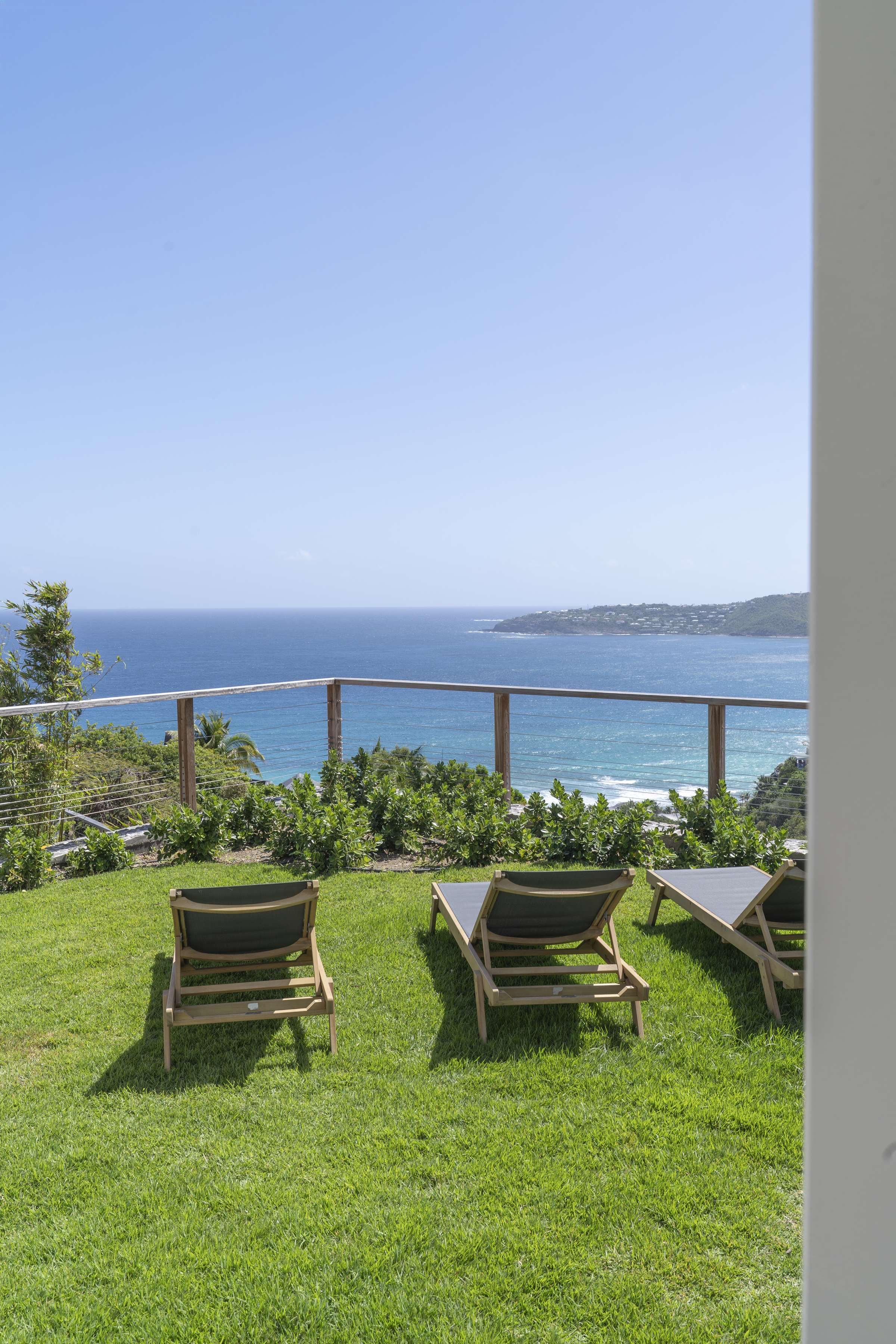 Lawn and teak sun loungers of Villa Ciel, with views toward Saint-Jean Bay, Saint-Barthélemy