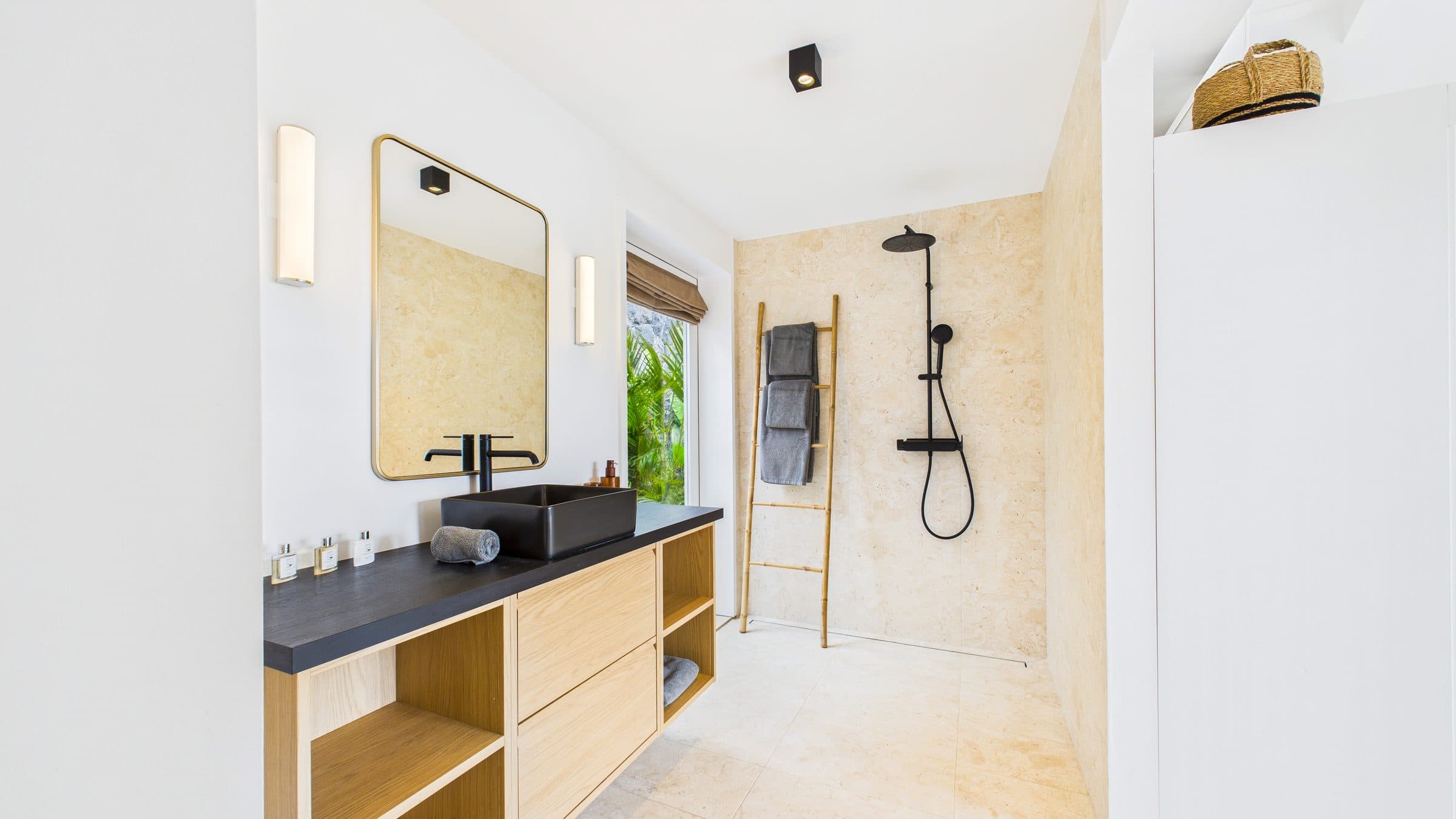 Ensuite bathroom with a black rectangular vessel sink on an oak vanity and an open stone-tiled walk-in shower