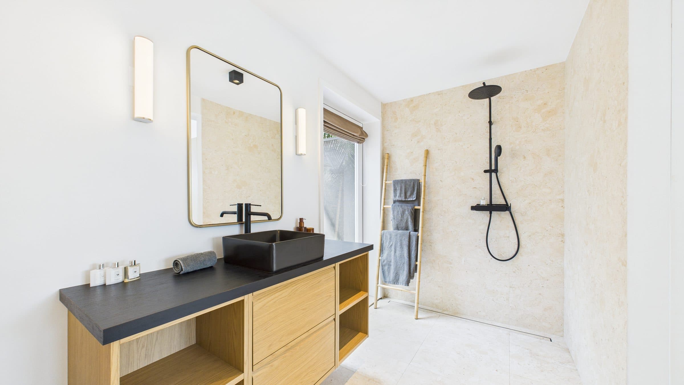 Second ensuite bathroom, black vessel sink under a brass-framed mirror, walk-in shower with rainfall head